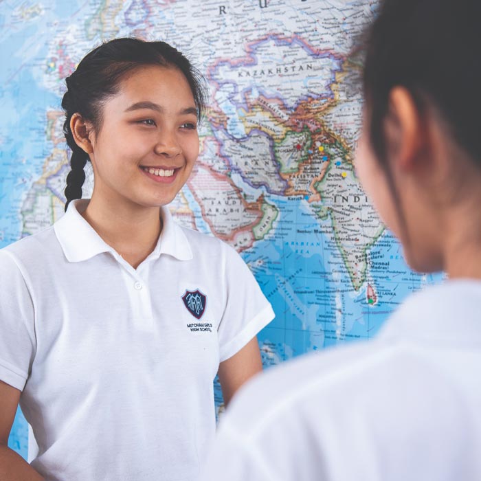 student in front of world map